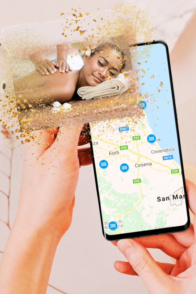 una donna tiene in mano un cellulare sul cui schermo appare la mappa della Romagna con alcuni stabilimentio tgermali che potranno usufruire del Bonus Terme 2021. In primo piano una donne che riceve un massaggio termale